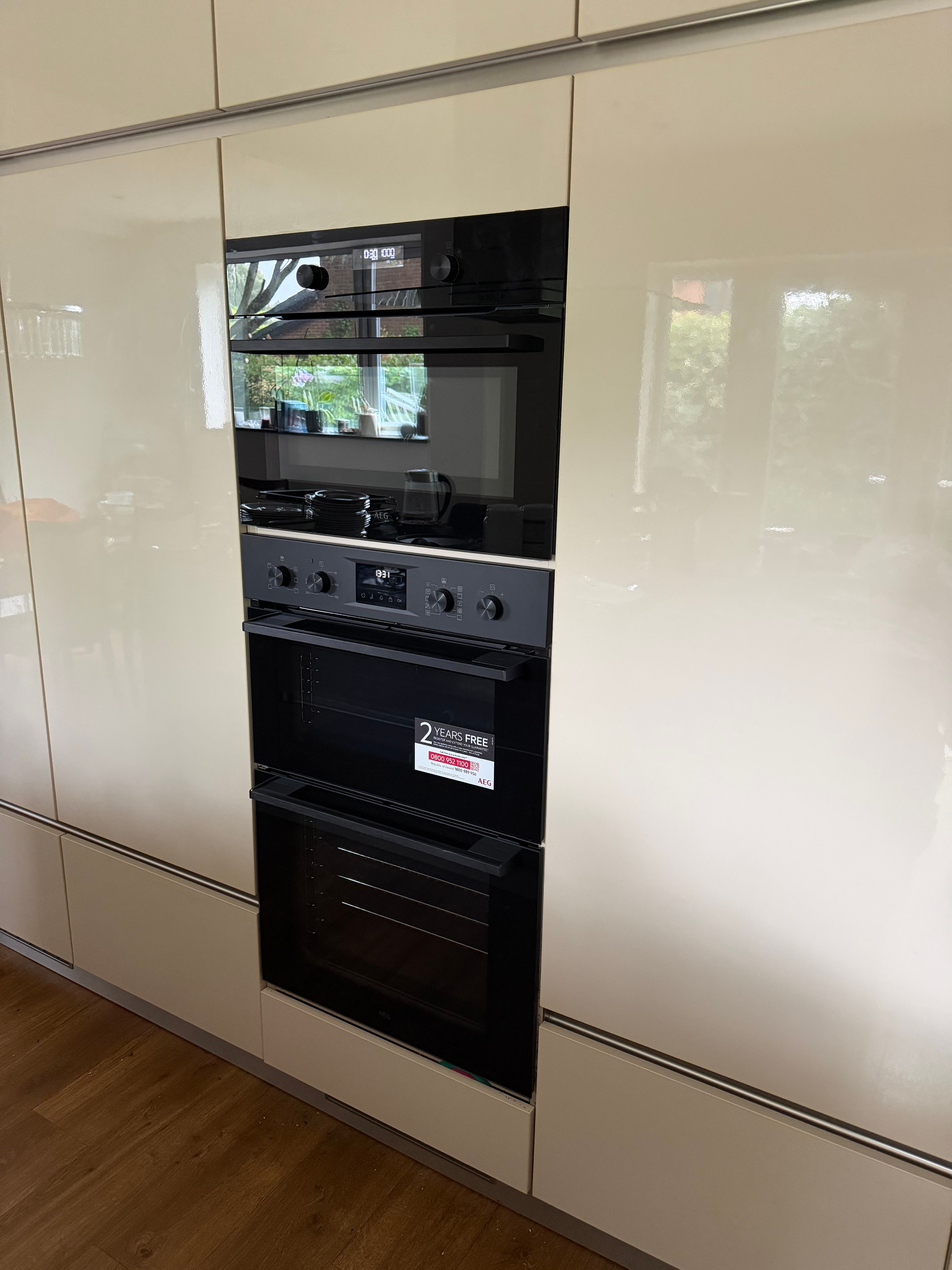Row of built-in AEG appliances installed in kitchen cabinetry